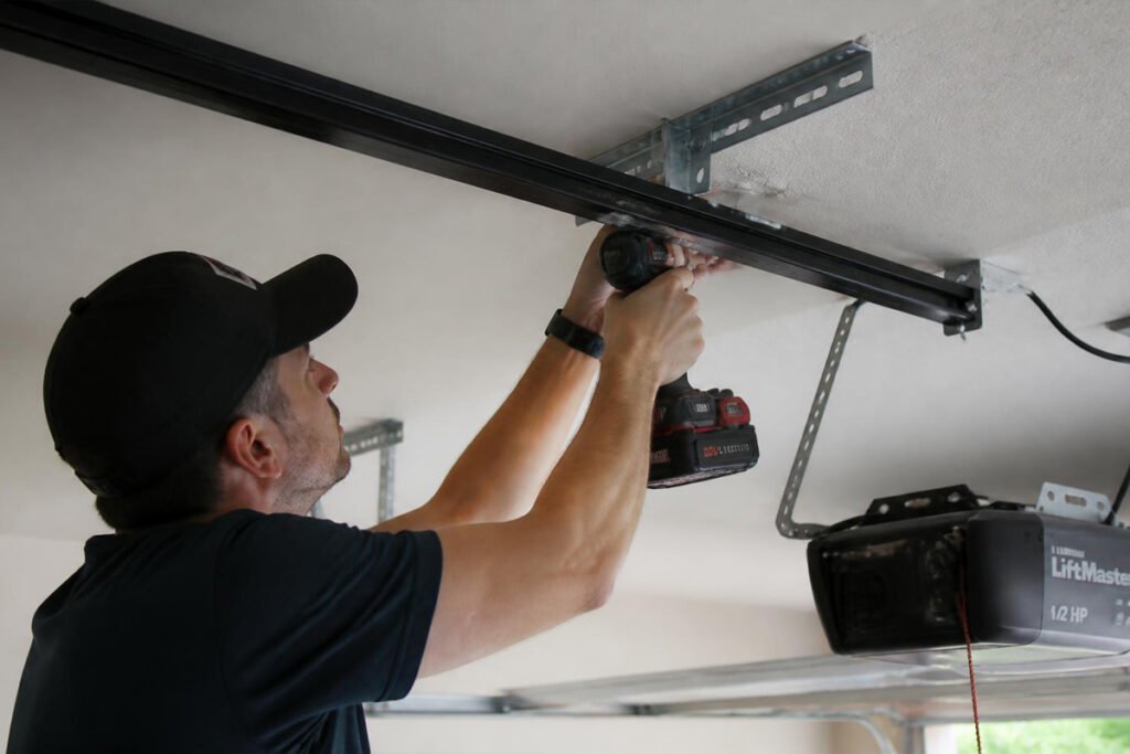 person installing garage door opener rail on ceiling bracket